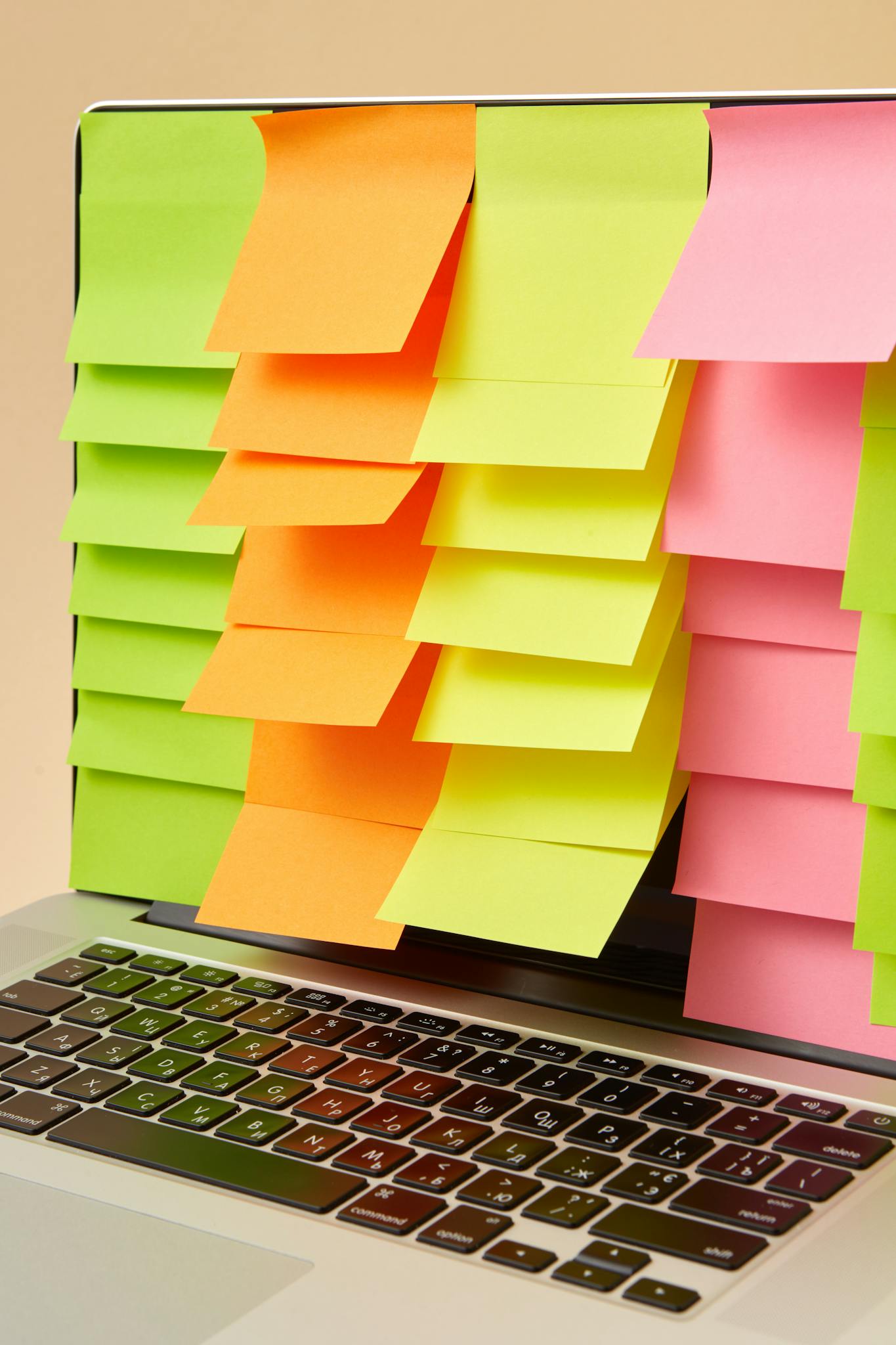 A laptop screen fully covered with vibrant sticky notes, showcasing modern tech and creativity.